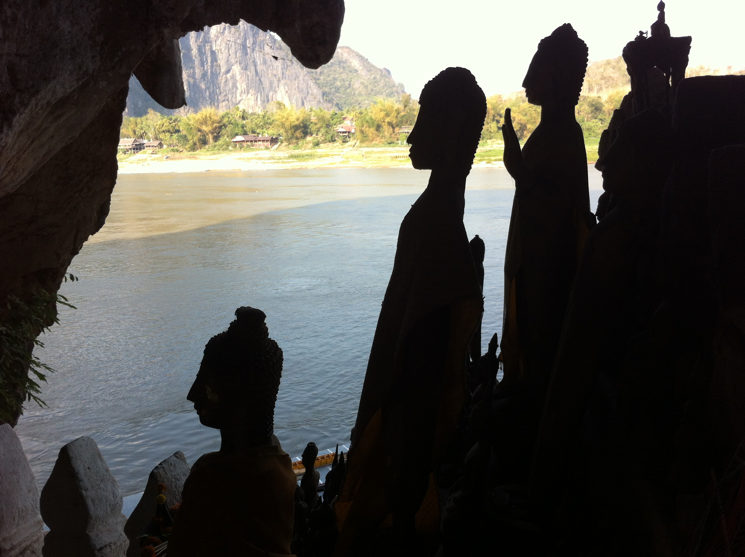 Buddha statues in silhouette with the mouth of the Nam Ou in the distance (photo Catherine Clover 2013)