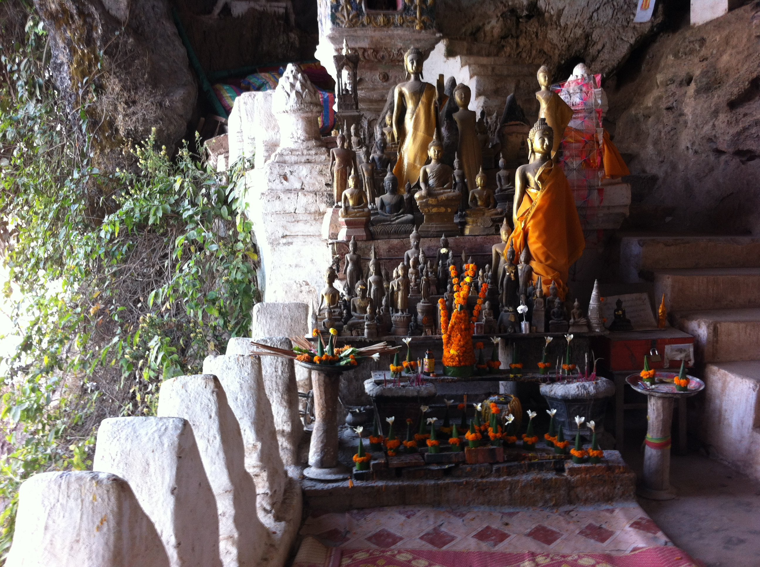 Gathering of Buddha statues at the mouth of the lower cave - same as those seen in silhouette in a different photo (photo Catherine Clover 2013)